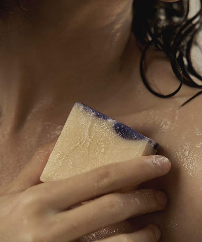 Woman using DONGGUBAT Field Dream Soap Cucumber Eggplant on shoulder