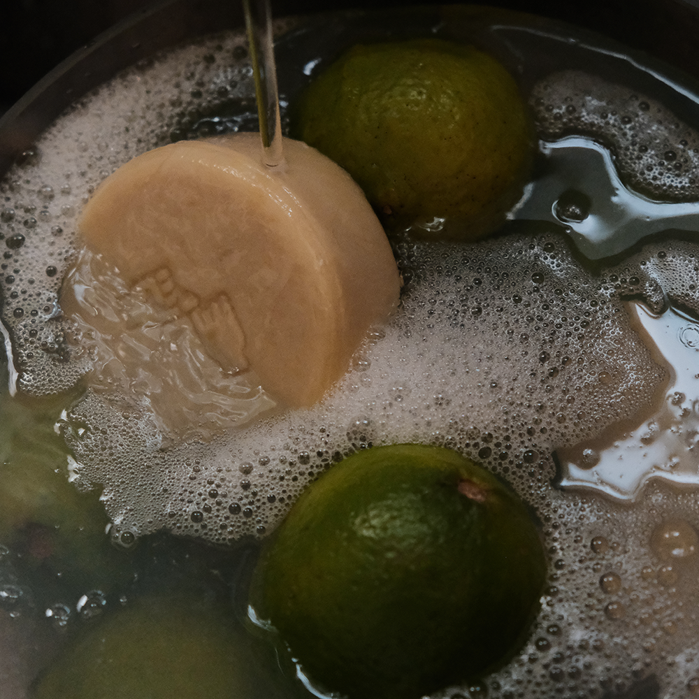 DONGGUBAT Dishwashing Soap Green Tangerine 100g in use with limes in soapy water