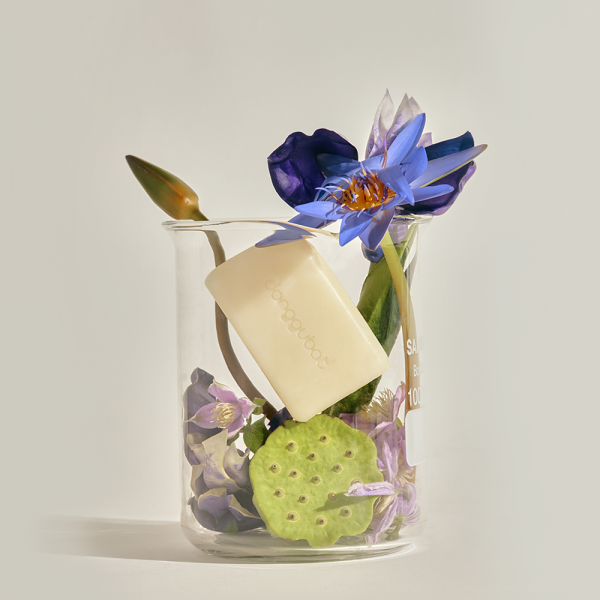 DONGGUBAT Field Blooming Perfume Shampoo Bar Volume 80g displayed with flowers in a glass container