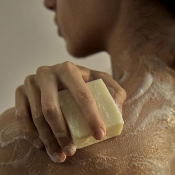 Person using DONGGUBAT Field Dream Soap Kale on shoulders, lathering soap for a refreshing cleanse.
