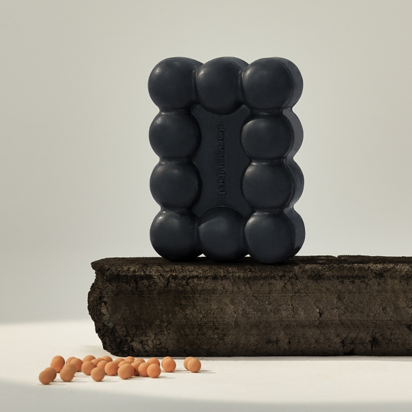 DONGGUBAT Gwalsa Therapy Scrub Shampoo Bar Geocharcoal 95g displayed on natural block with exfoliating beads.