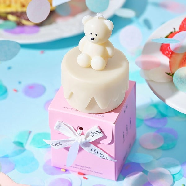 Cute bear figurine on a pastel box with colorful confetti background, evoking a cheerful celebration atmosphere.