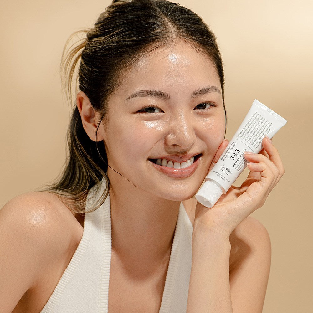 Smiling person holding DR ALTHEA 345 Relief Cream, showcasing skincare results