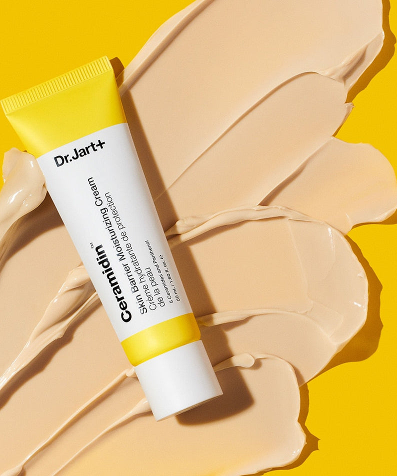 DR.JART+ Ceramidin Skin Barrier Moisturizing Cream 50ml tube on cream swatches against a yellow background