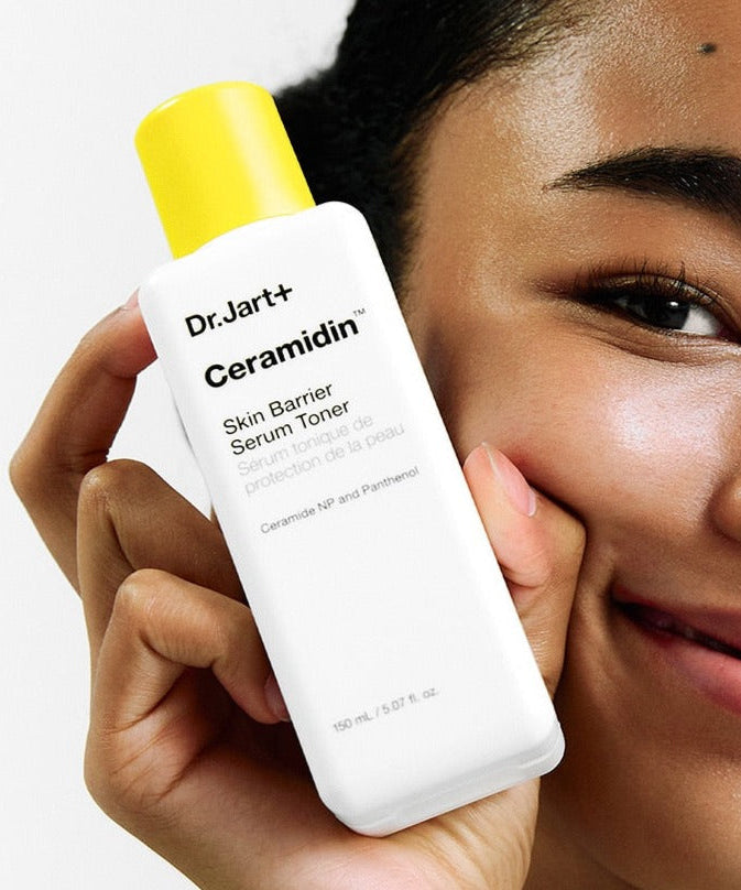 Person holding DR.JART+ Ceramidin Skin Barrier Serum Toner 150ml showing product packaging.