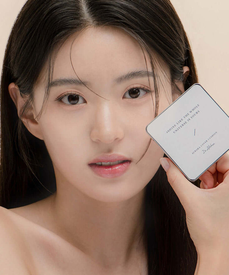 Woman holding DR.ALTHEA Aurora Cover Cushion 15g, showcasing luminous skin finish.