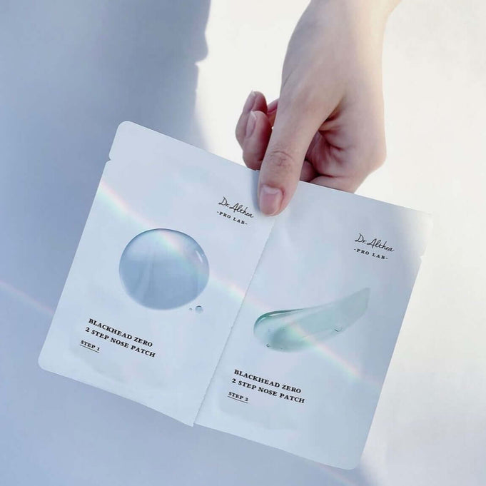 Hand holding DR.ALTHEA Blackhead Zero Two Step Nose Patch in white packaging against a light background.