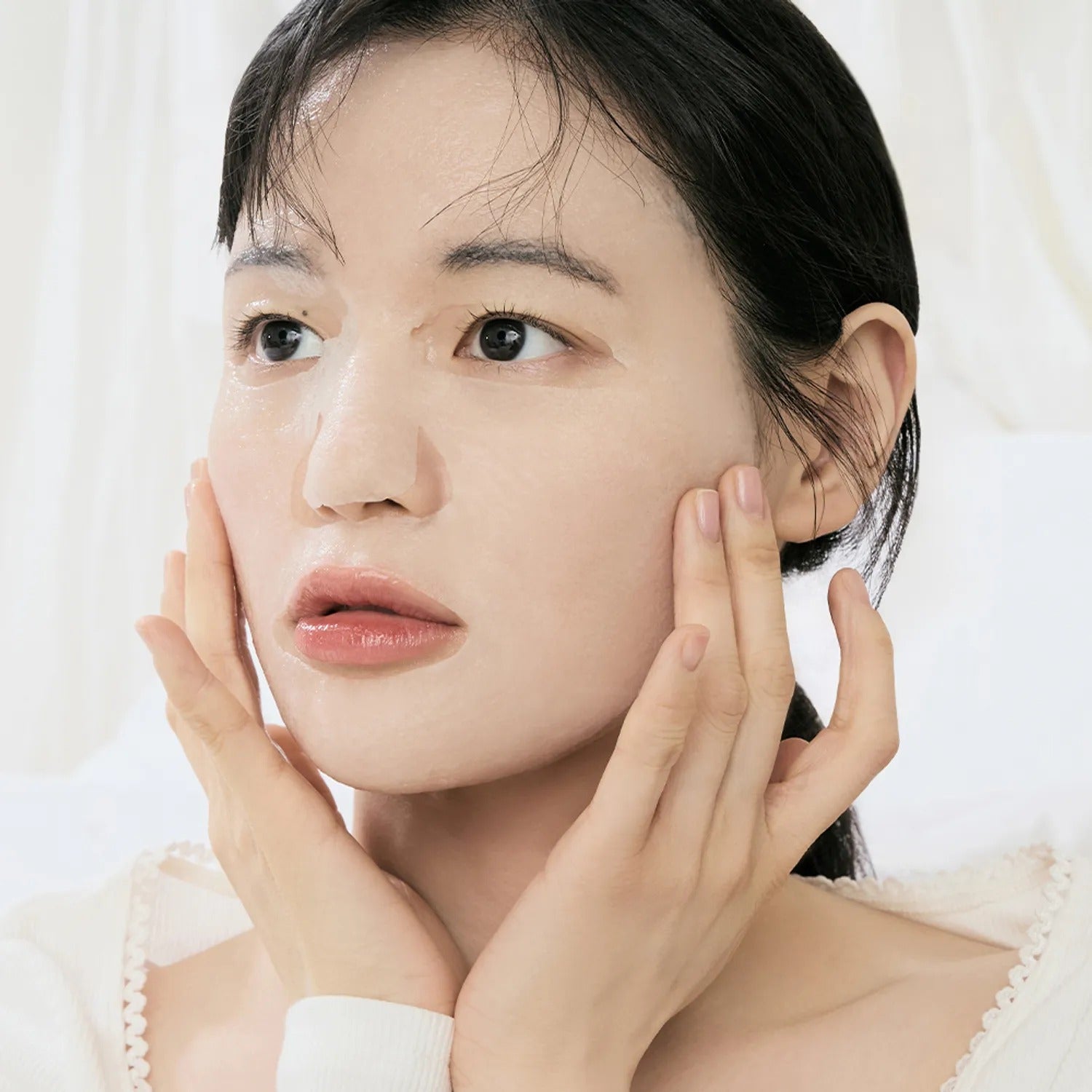 Woman using DR.ALTHEA Cushion Veil Calming Mask (4ea) for soothing skin care.