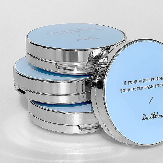 Stack of DR.ALTHEA Double Serum Night Foundation 12g compacts with blue lids and reflective borders.