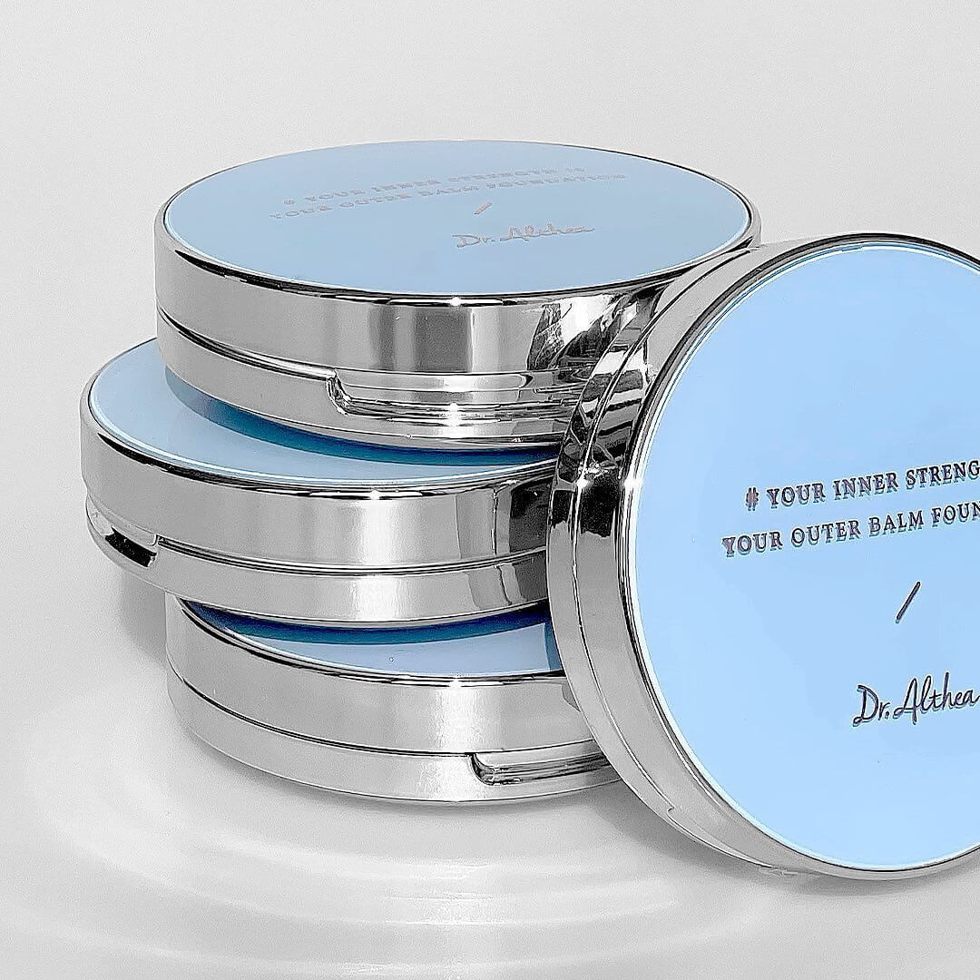 Stack of DR.ALTHEA Double Serum Night Foundation 12g compacts with blue lids and reflective borders.