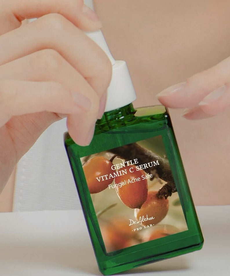 Woman holding DR.ALTHEA Gentle Vitamin Serum 30ml bottle with dropper, skincare product for gentle hydration and nourishment.