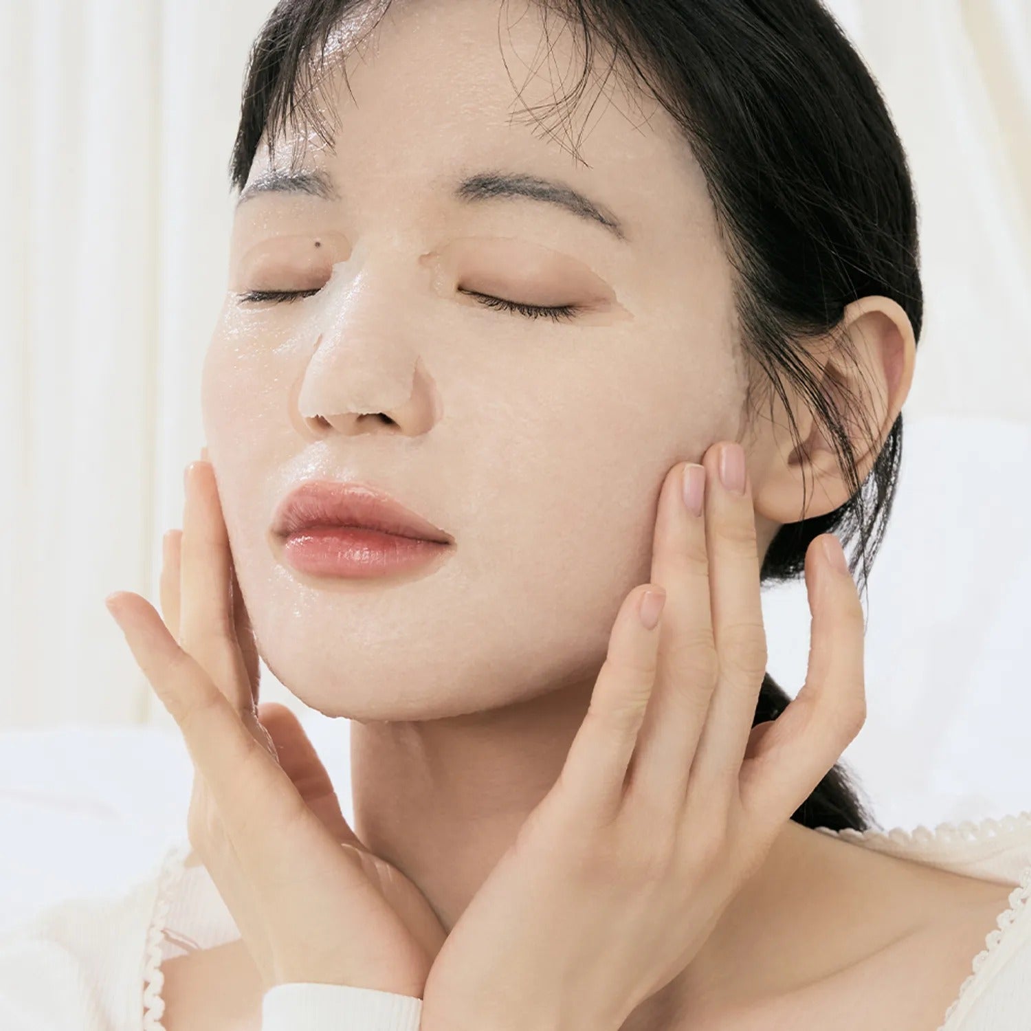 Woman applying DR.ALTHEA Jelly Seal Dewy Mask (4ea) for a hydrated skincare routine in elegant, serene setting.