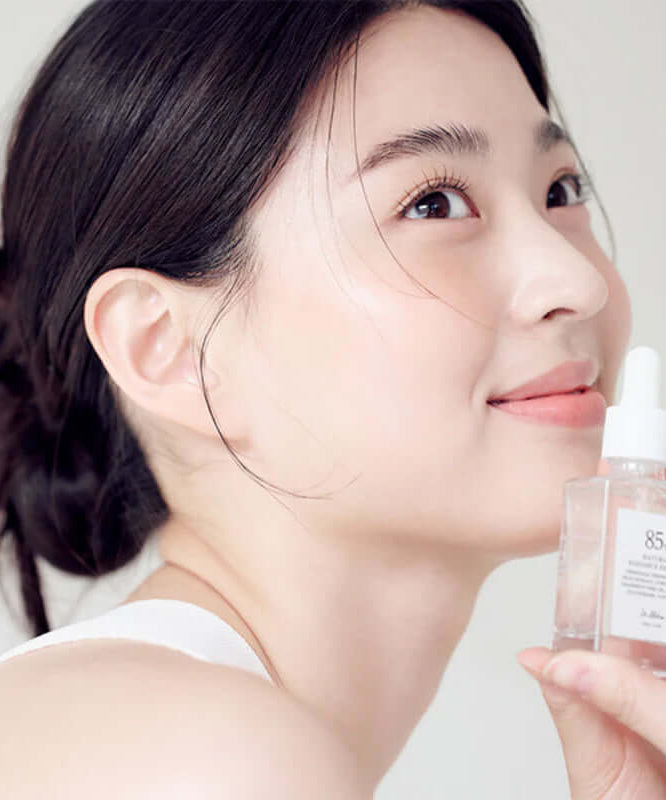 Woman holding DR.ALTHEA Natural Radiance Essence 30ml bottle, showcasing skincare product effectiveness.
