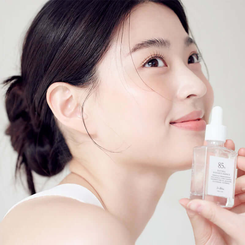 Woman holding DR.ALTHEA Natural Radiance Essence 30ml bottle, showcasing skincare product effectiveness.