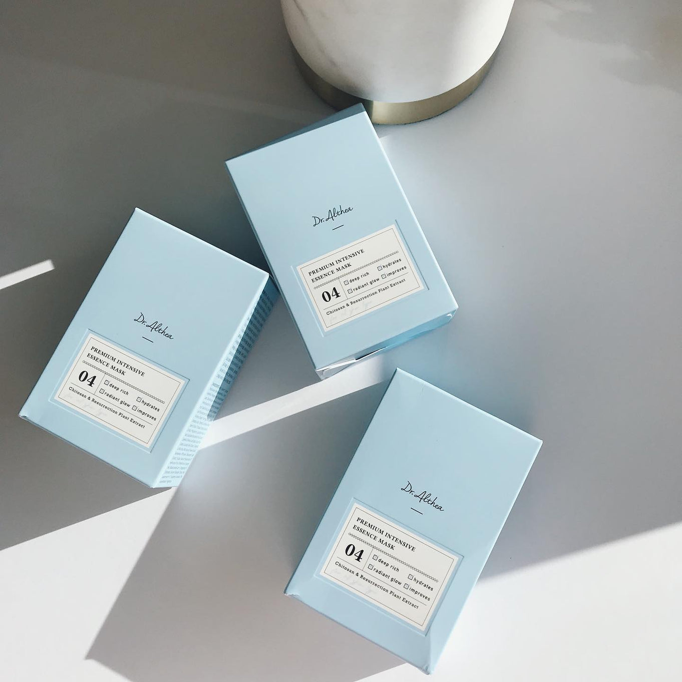 Three boxes of DR.ALTHEA Premium Intensive Essence Mask on a table.