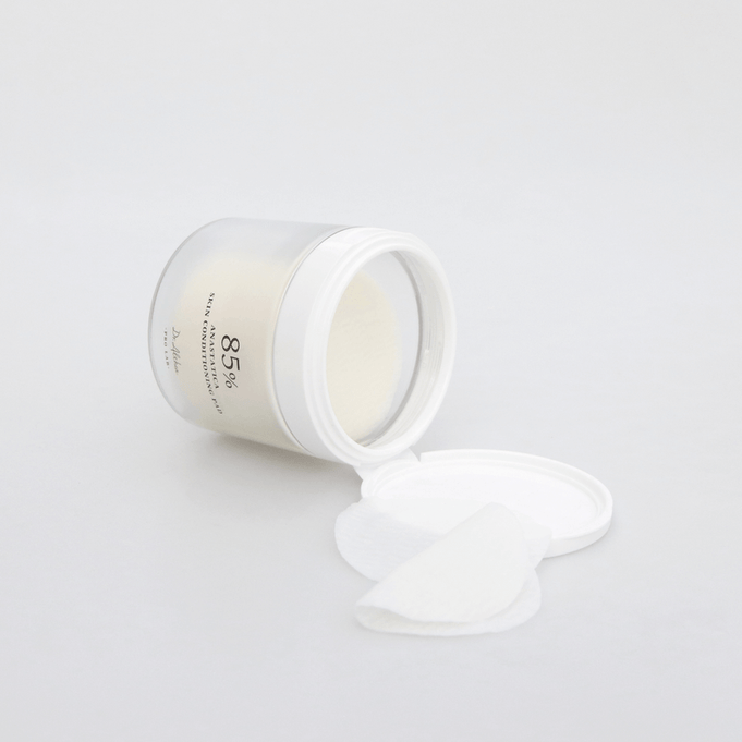 Open jar of DR.ALTHEA Resurrection SKin Conditioning Pad 170g with pads spilling out on a white surface, emphasizing skincare benefits.