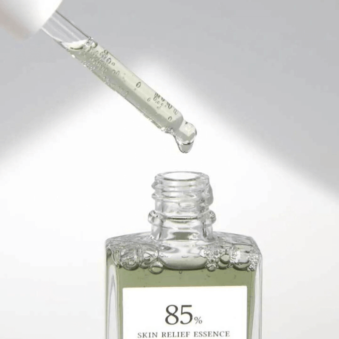 Close-up of dropper dispensing DR.ALTHEA Skin Relief Essence 30ml serum into an open bottle, highlighting product texture and clarity.