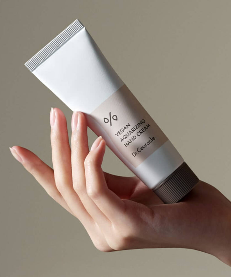 DR.CEURACLE Aqua Rising Hand cream 50ml held in hand, elegant tube design