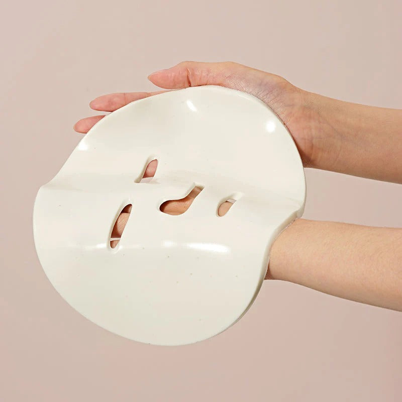 Person holding DR.CEURACLE Expert Collagen Firming Modeling Mask 30g, showcasing the smooth texture of the skincare product.
