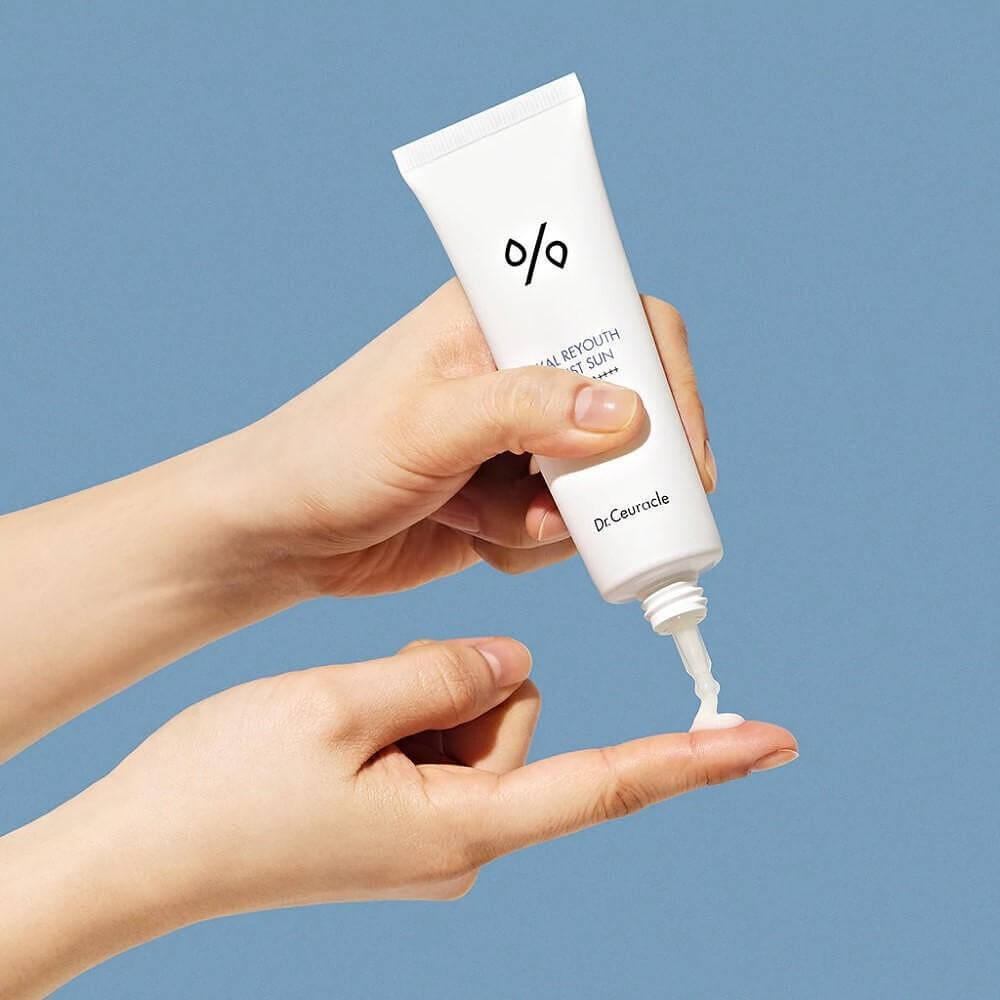 Applying DR.CEURACLE Hyal Reyutsu Moist Sun SPF50+,PA++++ sunscreen on hand.