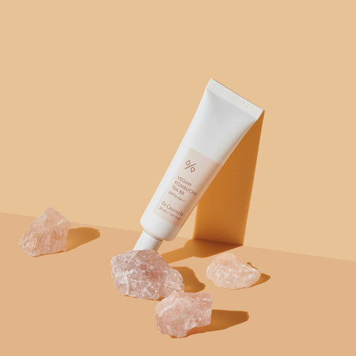 DR.CEURACLE Vegan Kombucha Tea BB SPF30 PA++ 30ml tube with pink stones on a peach background