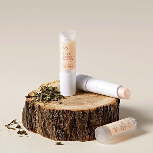 DR.CEURACLE Vegan Kombucha Tea Lip Balm on wooden surface with tea leaves