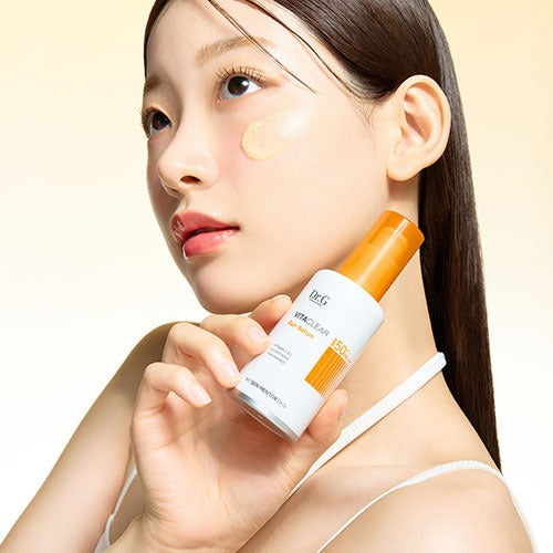 Model holding DR.G Vita Clear Sun Serum 50ml, showcasing skincare application and product benefits.