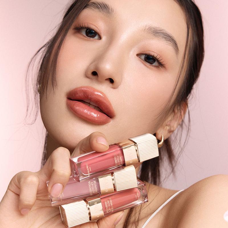 Model showcasing D'ALBA Plumping Lip Glow Mood Volumizer 5ml with pink and nude shades, highlighting its plumping effect and glossy finish.