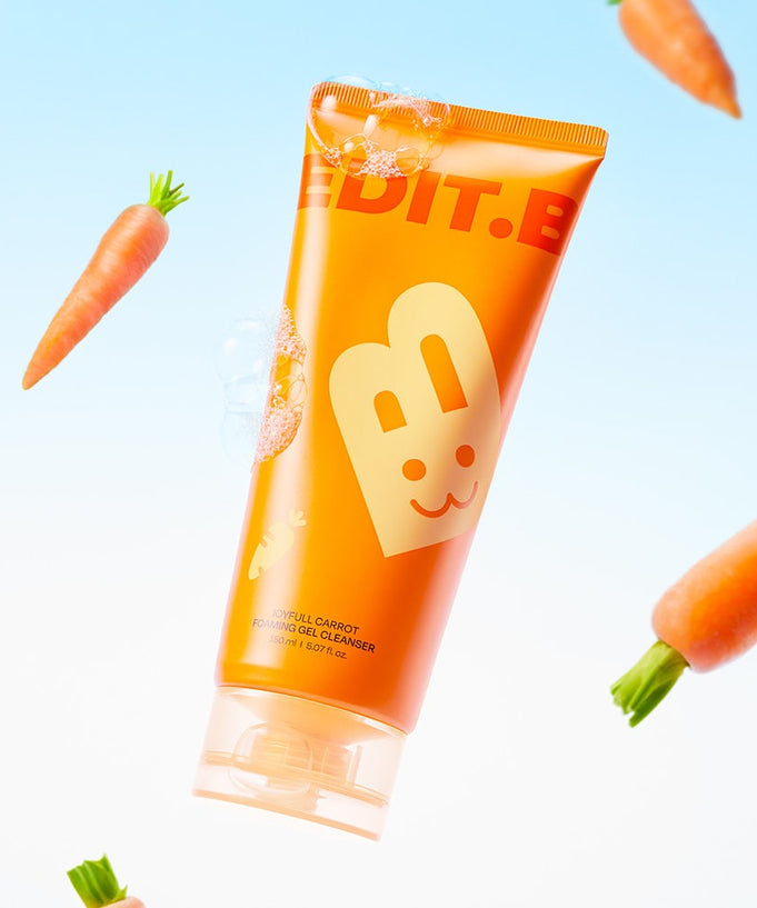 EDIT.B Joyful Carrot Foaming Gel Cleanser 150ml bottle surrounded by floating carrots on a light blue background