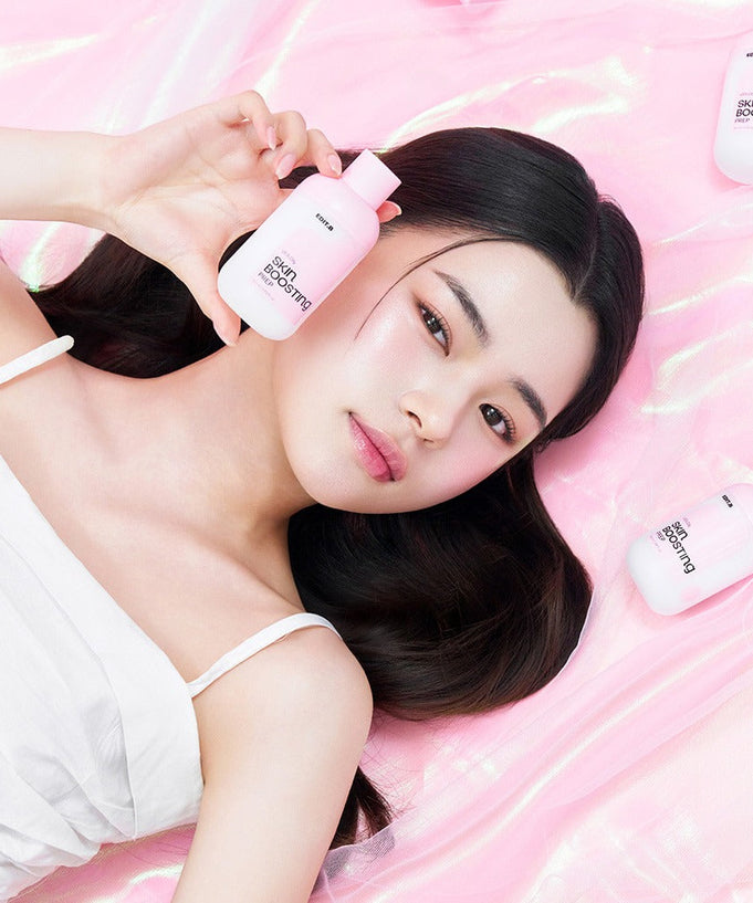 Woman holding EDIT.B Veil On Skin Boosthing Prep 50ml on pink background