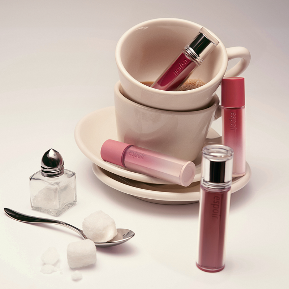 ESPOIR Couture Lip Tint Glaze [NEW COLOR] displayed with elegant cups and sugar cubes in a stylish setup