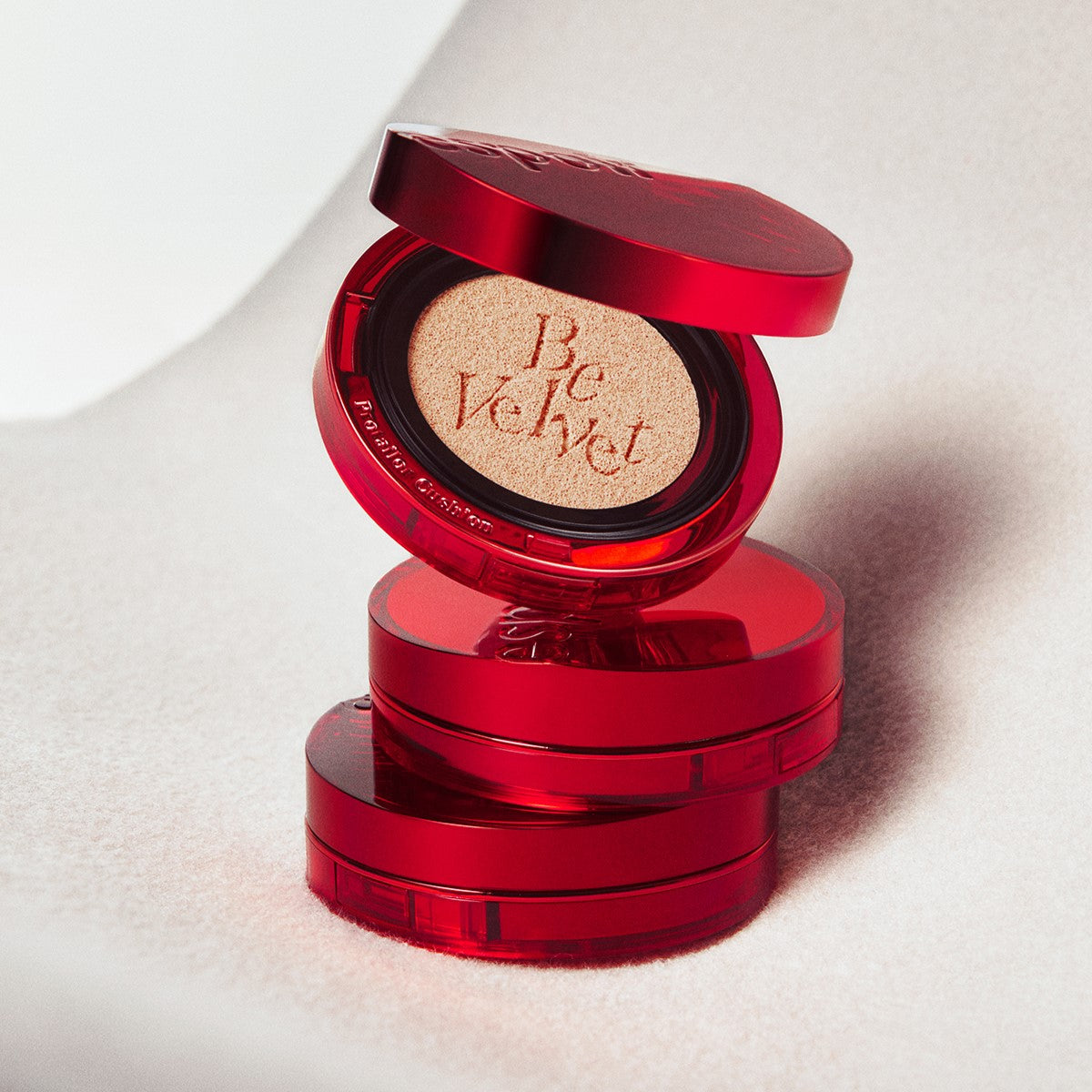Stack of ESPOIR Pro Tailor Be Velvet Cover New Glass Cushion compacts in vibrant red packaging.