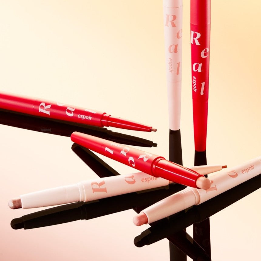ESPOIR Real Eye Aegyosal Stick in various colors displayed on a reflective surface. Enhance your eye makeup with ESPOIR Real Eye Aegyosal Stick.
