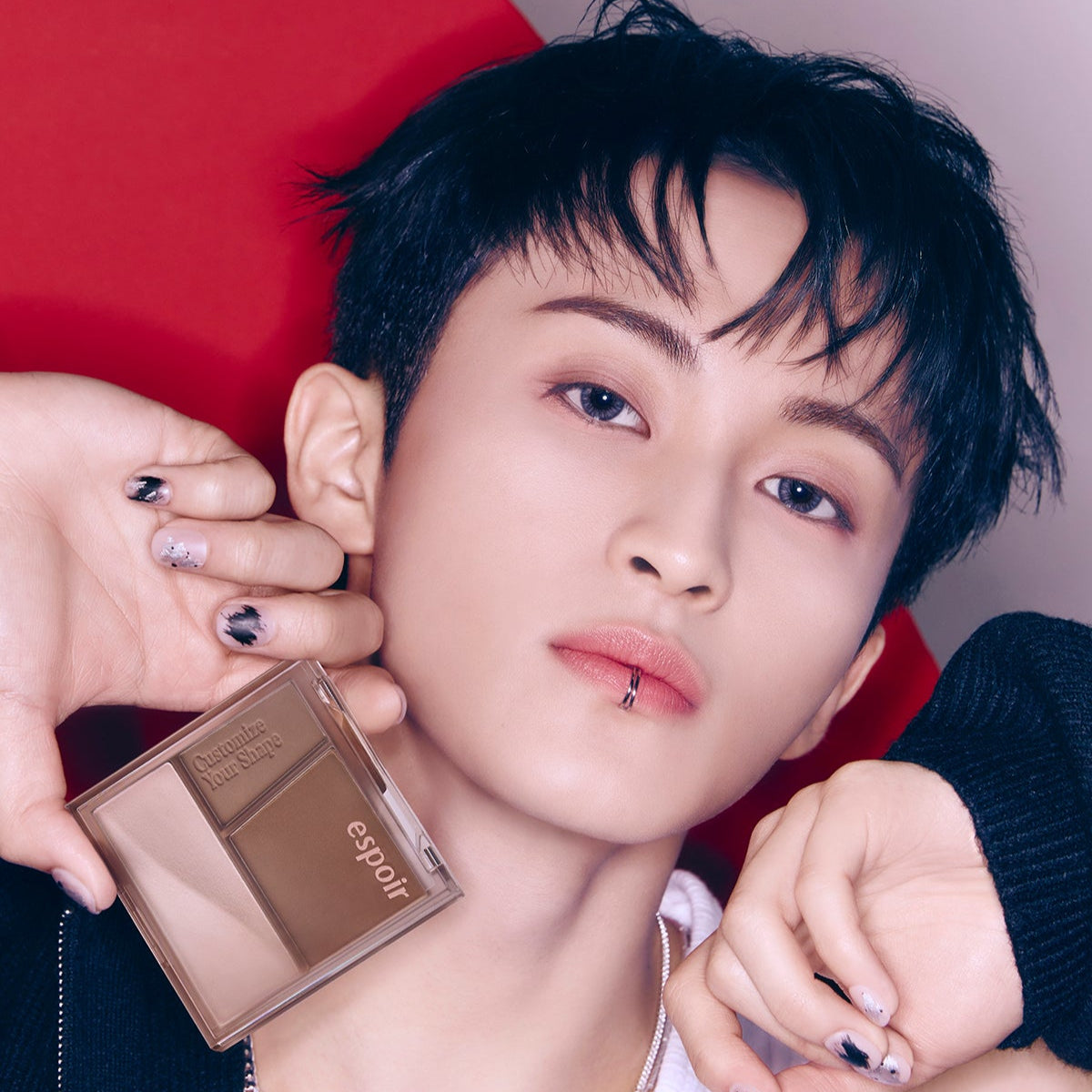 Person holding ESPOIR Tone Pairing Contour Palette in front of their face, showcasing the makeup product in a stylish manner.