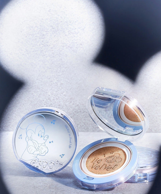 ESPOIR Bevelvet Cover Cushion SPF42/PA++ [Disney Edition] with Mickey Mouse design, showcasing compact and cushion details on a textured surface.