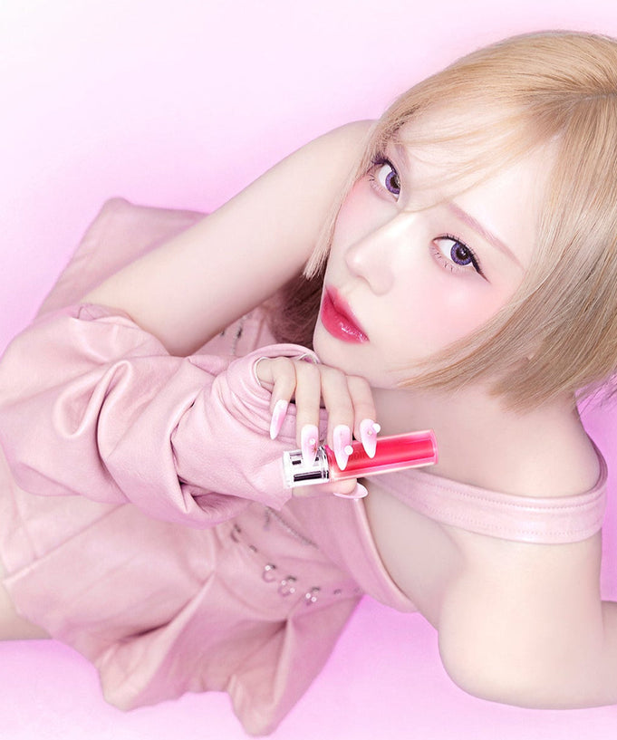 Person holding ESPOIR Couture Lip Tint Glaze in a pink setting