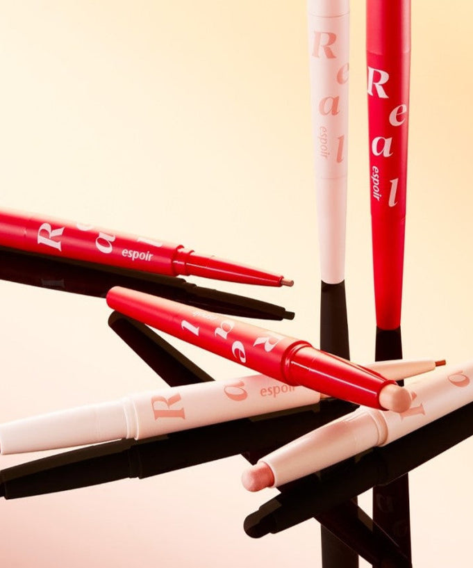ESPOIR Real Eye Aegyosal Stick in various colors displayed on a reflective surface. Enhance your eye makeup with ESPOIR Real Eye Aegyosal Stick.