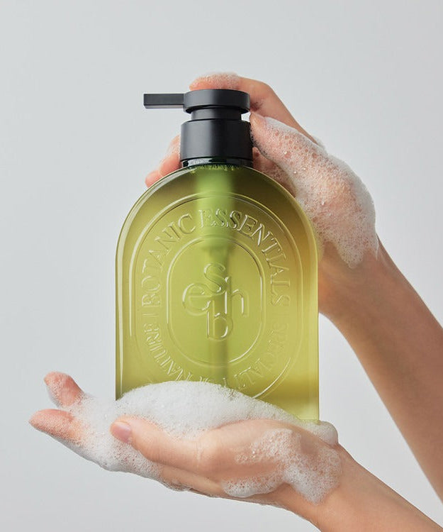 Person holding bottle of ESSENHERB Acne Tea Tree Daily Body Wash 500ml with foam