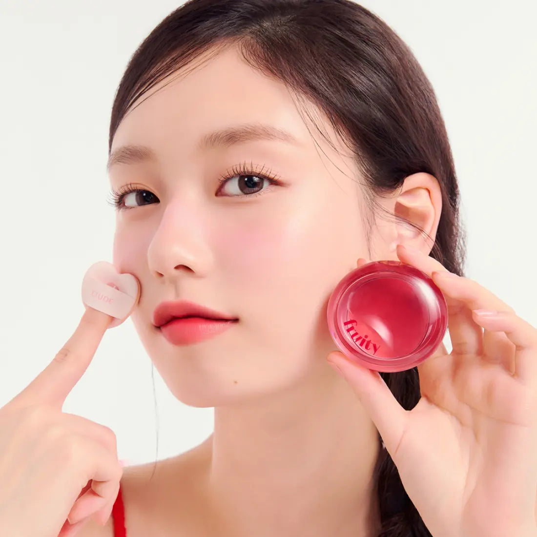 Model applying ETUDE Fruity Lip & Cheek Blur Balm 2.3g on cheek, showcasing vibrant color and smooth texture.