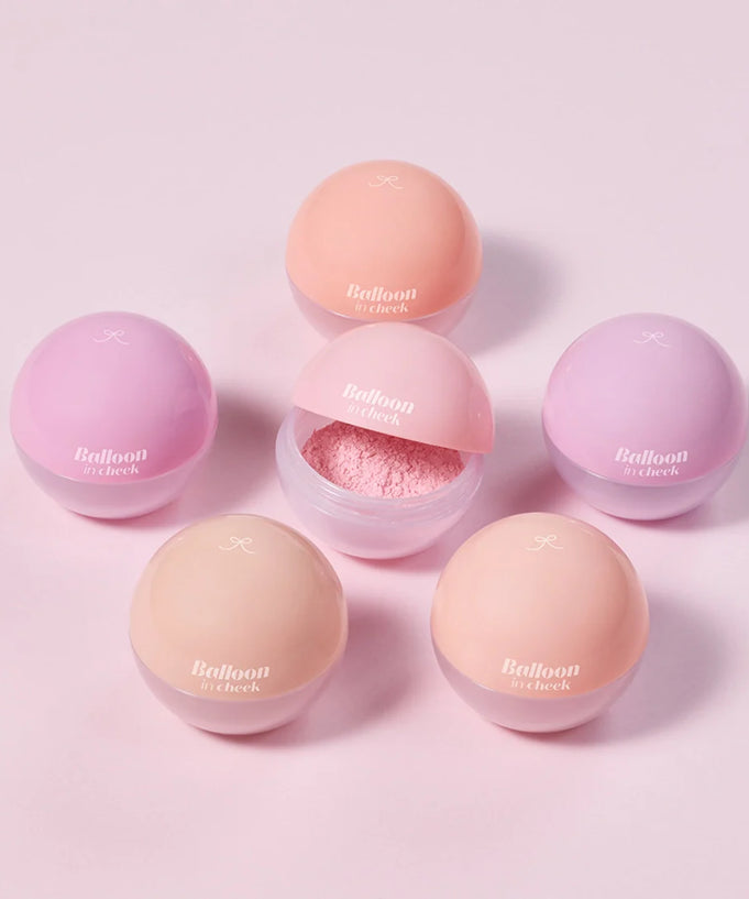 Assorted ETUDE Balloon in cheek 6g blush shades in spherical containers on a pink background.