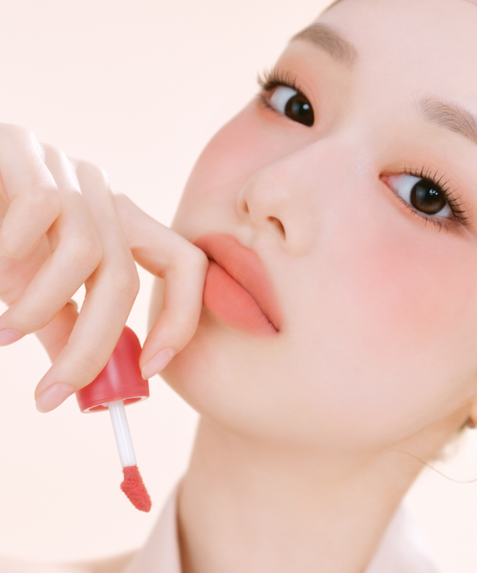 Model applying ETUDE Cozy Fixing Tint 4g to lips, showcasing rich color and smooth finish.