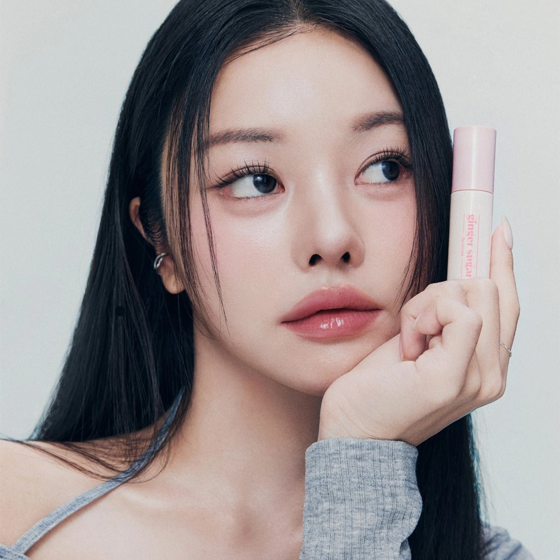 Woman holding ETUDE Ginger Sugar Lip Serum 13g, showcasing the lip care product in hand.