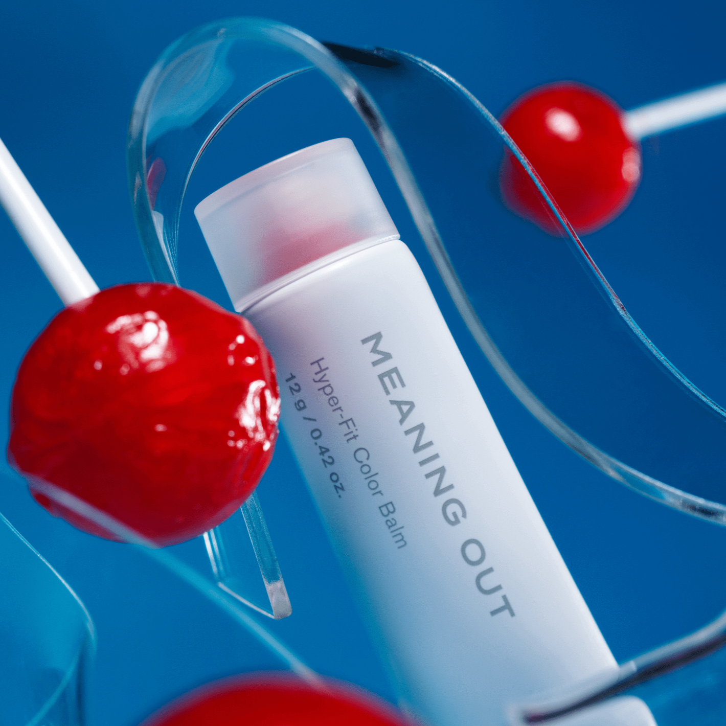 FEEV Hyper-Fit Color Balm with vibrant design, surrounded by red lollipops, offering a smooth and lasting color experience.