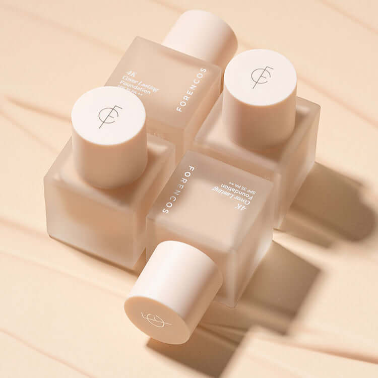 Three bottles of FORENCOS 4K Cover Lasting Foundation 30ml arranged on a beige background.
