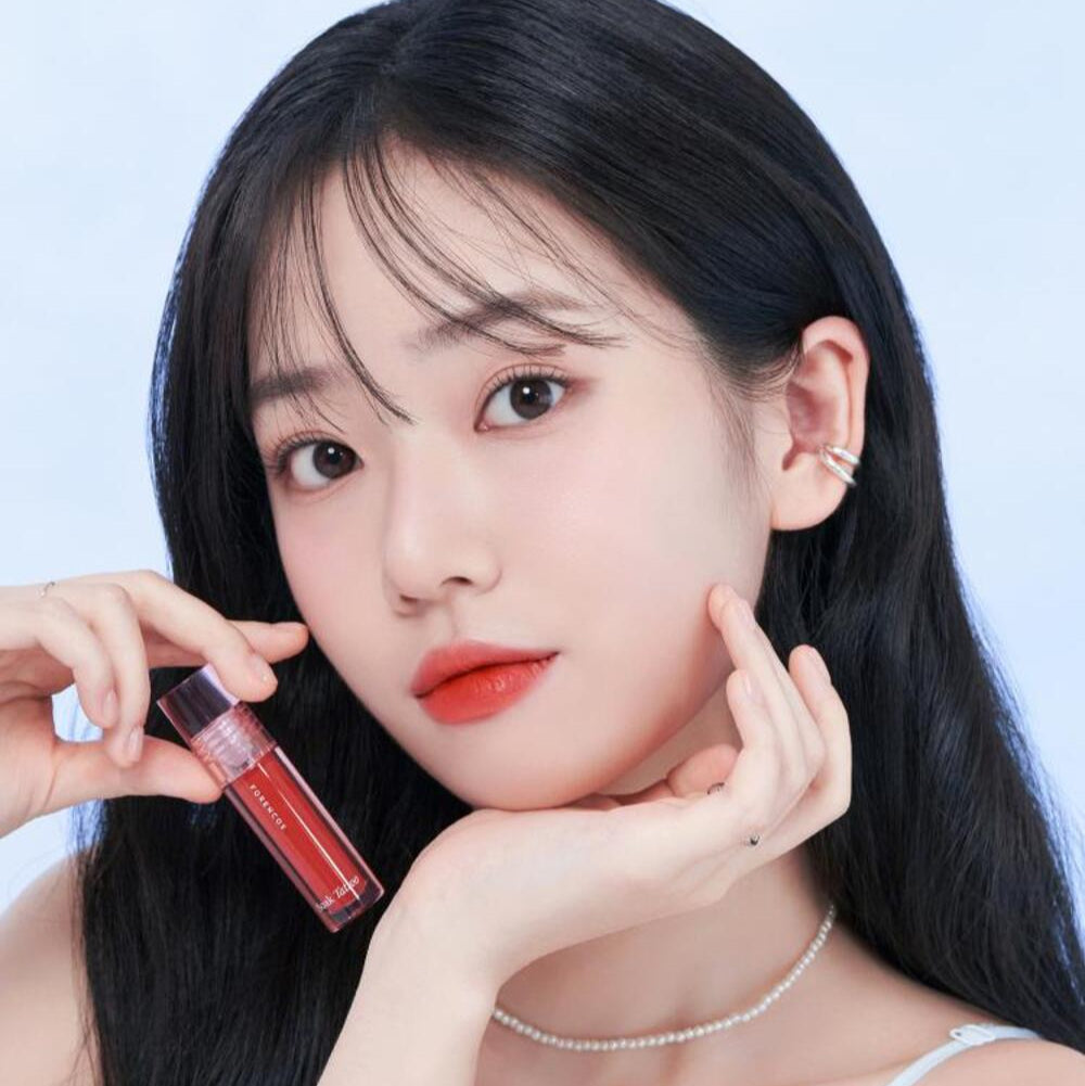 Woman holding FORENCOS Renewal Tattoo Tint with a soft makeup look.