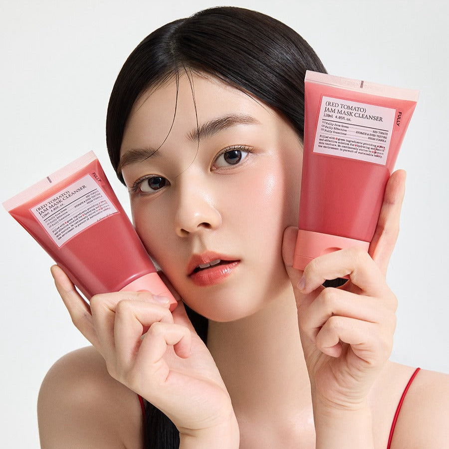 Woman holding two tubes of FULLY Red Tomato Jam Pack Cleanser 120ml with fresh complexion.
