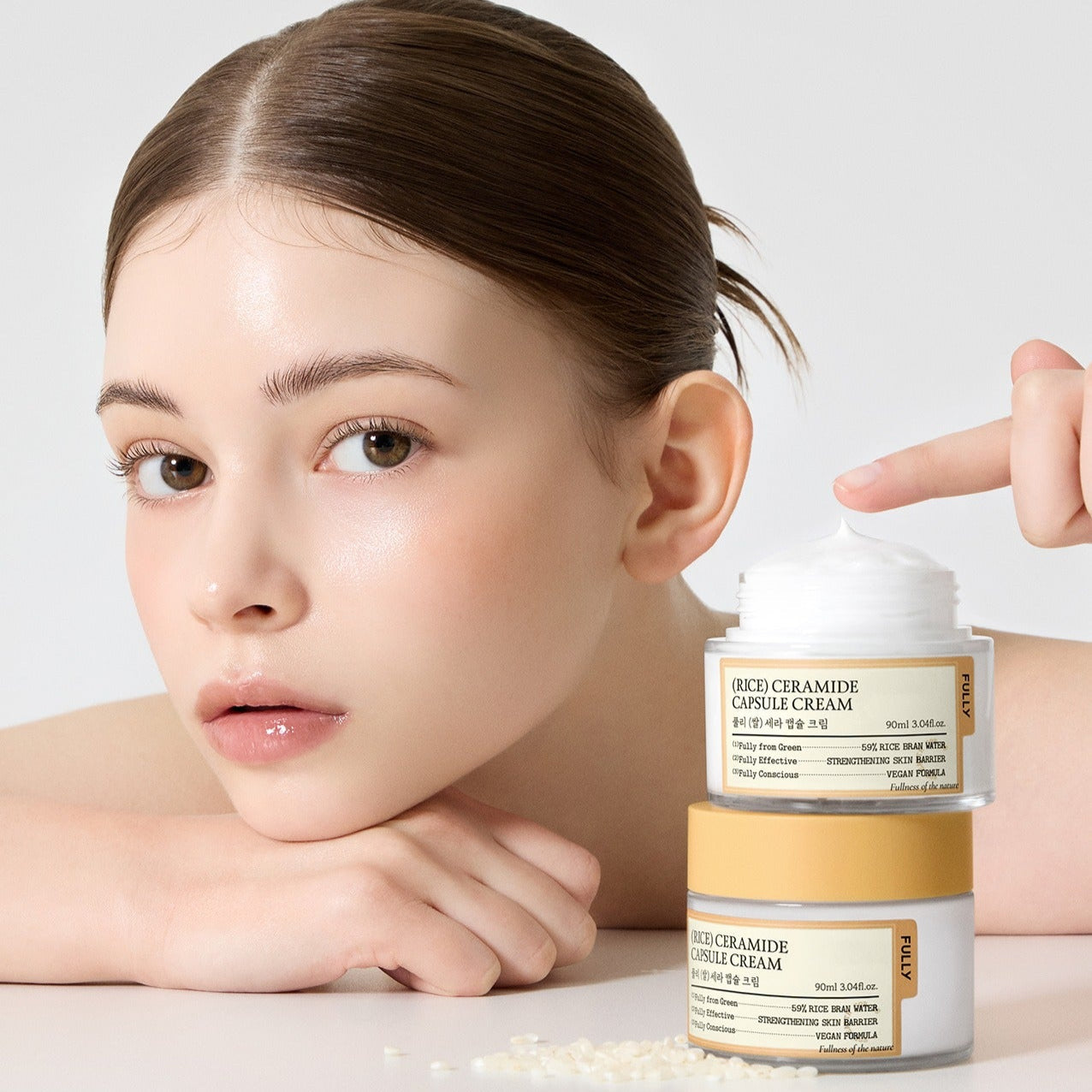 Woman showcasing FULLY Rice Sera Capsule Cream 90ml jar with smooth, glowing skin.