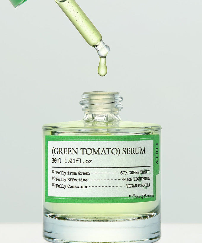 Bottle of FULLY Green Tomato Serum 30ml with dropper dispensing serum, vegan formula, skincare product.