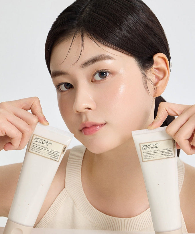 Person holding tubes of FULLY Job's tears niacin grain pack 120ml skincare product