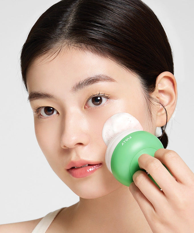 Woman using FULLY Pore brush with green handle for facial cleansing, showcasing skincare routine and effective pore care tool.